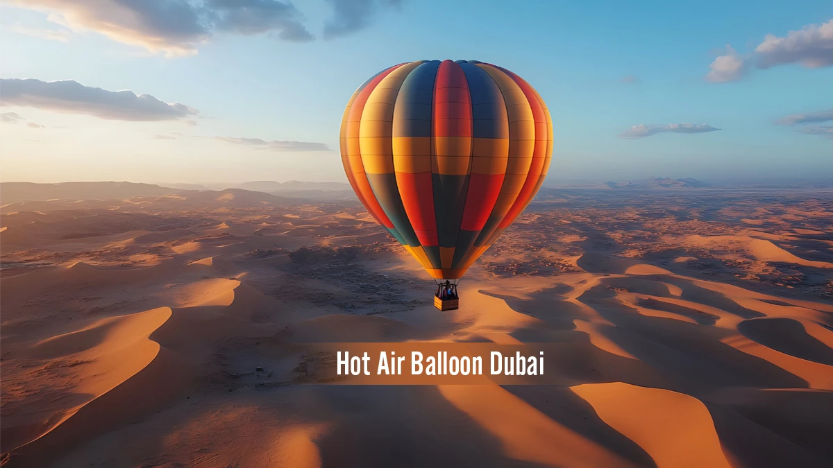 Hot air balloon flying over the golden sand dunes of Dubai desert during sunrise